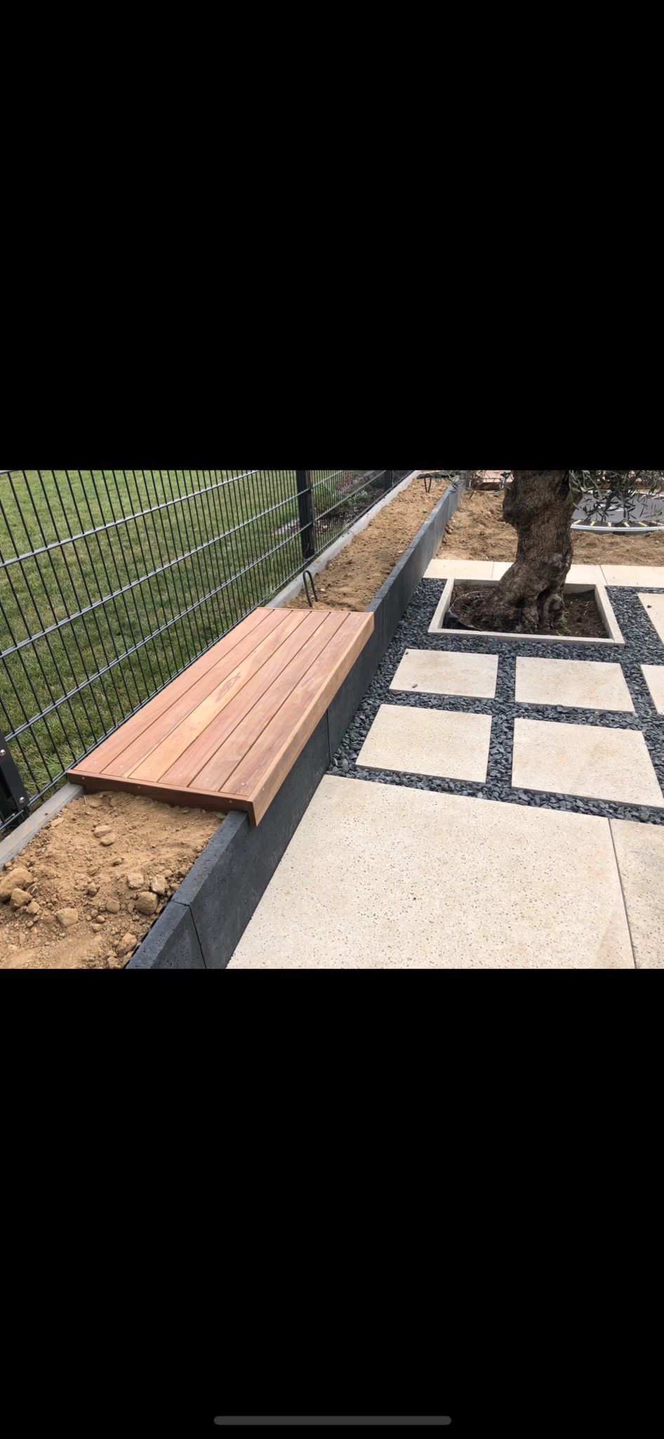 Moderner Gartenweg mit Holzbank und Steinplatten